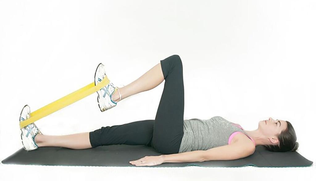 HIP FLEXION IN LYING (BEGINNER) Step 1: Lie down on your back and place the resistance band around the outside of your shoes Step 2: Gently squeeze your lower abdominal muscles (by drawing your belly