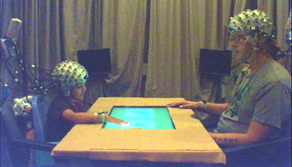 Figure 1: Child and parent playing the bubble game while EEG was recorded 2.
