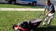Video GT A man is seen pushing a lawn mower across a lawn to cut the grass Ours A man