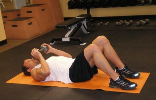 12 Lying DB Crunches - Lie flat on a mat with your knees bent and both feet flat