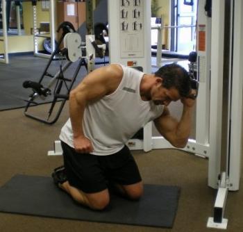 35 One Arm Cable Crunch - Start in a kneeling position with one side of your body facing a cable machine.
