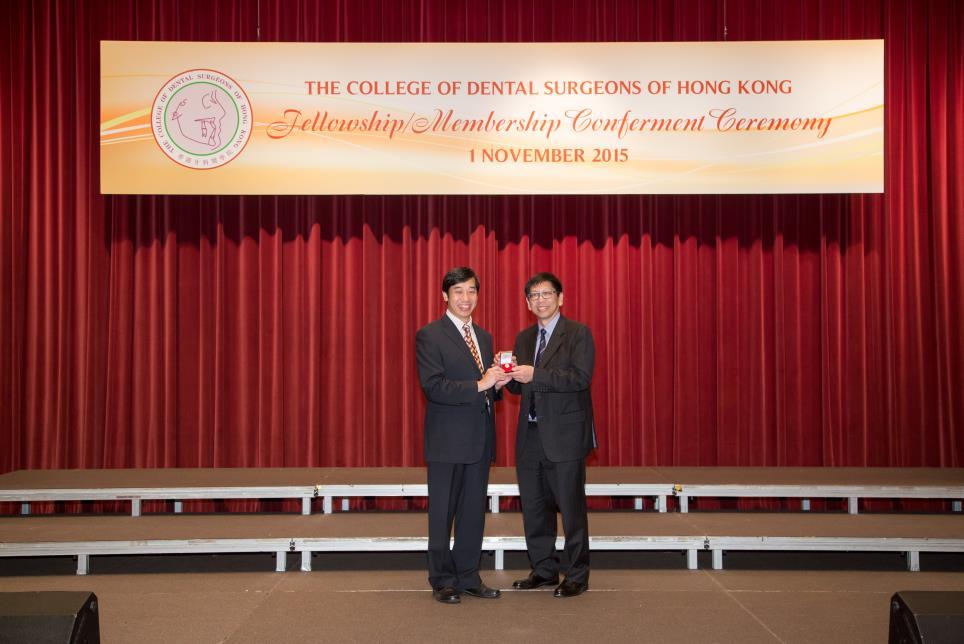 Professor Edward C M LO (left) received the Meritorious Service pin from Dr Sai Kwing CHAN Professor Edward C M