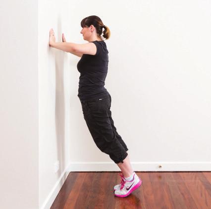 Standing on the balls of your feet, bend at the elbows to lower your body towards the wall (you should be almost close enough to kiss the wall).