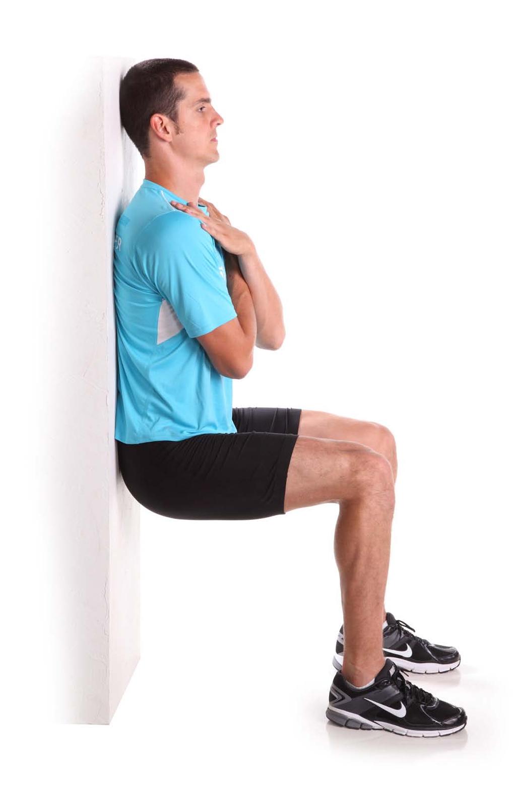 Keep your weight on your heels and your back pressed into the wall for support. Slowly bend your knees and lower your body so that your thighs are parallel to the floor.