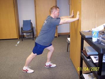 Keeping legs straight, but not locking knees bend forward at the waist.