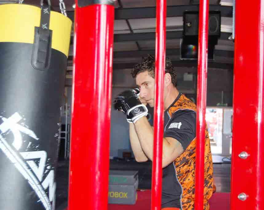 The rig features a variety of stations including an Adjustable Pulley, punchbag, medicine ball rebounder, chin up, functional