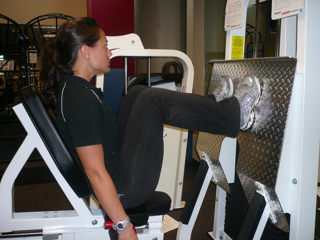 Round 4: Lower Body Exercises: Leg Press Machine: Begin by sitting on the leg press machine with your feet flat on the foot plate.