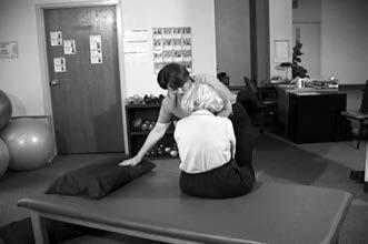 While supporting the weight of their upper trunk through the scapula, make sure you stay directly in front of the patient.