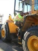 Skidsteer: The operator steps up on top of the loader and opens the door to the cab.