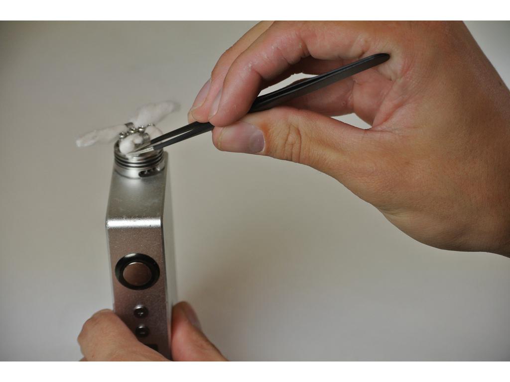 Step 23 Tuck cotton underneath coils and into the well of the atomizer using the tweezers.