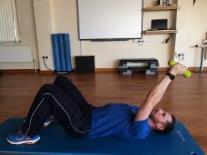 Maintaining forearm contact with the wall slide your arms up the wall, return to the start position and repeat.