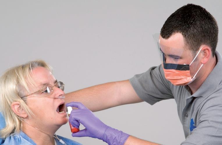 position close to mouth, without touching Firmly press button to release spray under patient