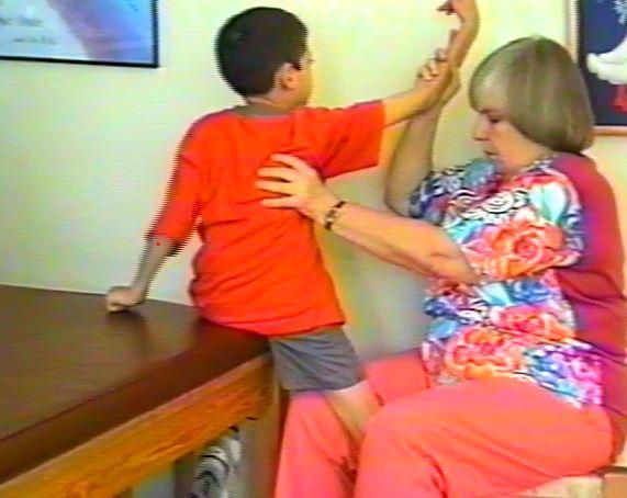 Once there is more dissociation of the pelvic girdle with the trunk, and more active hip extension, the therapist places the child in a more functional position in standing in order