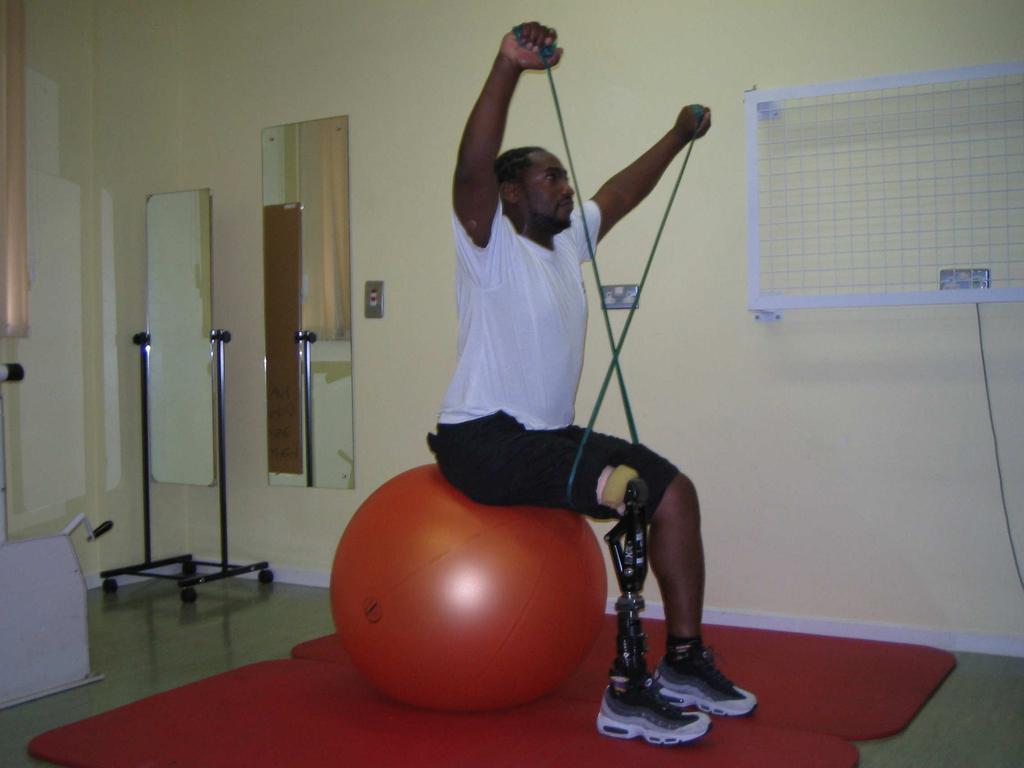 Thera-band above head pulling outwards with thighs against the Thera-Band Push the ball backwards away