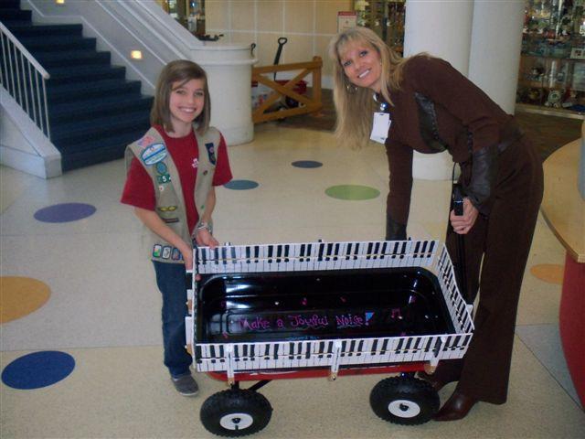 Rebecca Bender (former Patient) is shown donating a wagon to