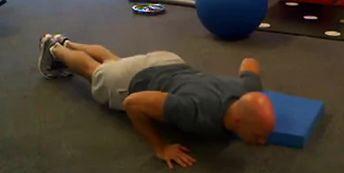 Place the left hand on the floor and the right hand elevated 4-6 inches on an aerobic step. Hands are slightly wider than shoulder width apart (normal pushup width).