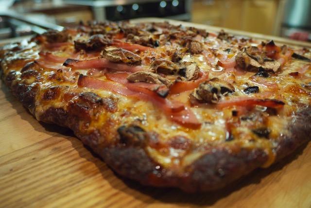 Topped with pizza sauce, pepperoni, onions, mushrooms, green onions
