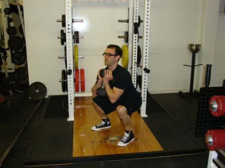 KB Goblet Squat Stand with your feet just greater than shoulder-width apart.