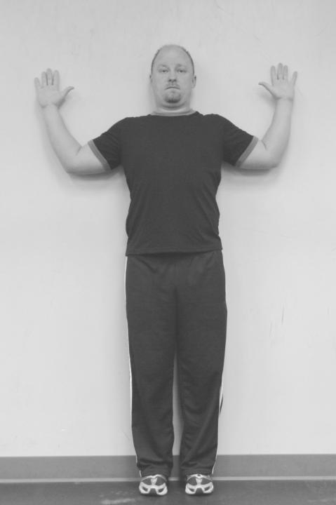 Tuck chin slightly to create flexion in upper cervical spine. Relax and inhale, exhale slowly while pressing back of head and arms against wall.