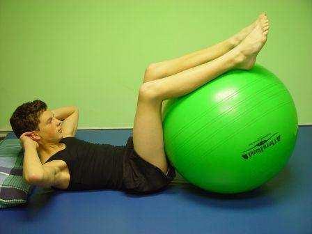 14. LYING CRUNCH: Lie on back with ball under bent legs,
