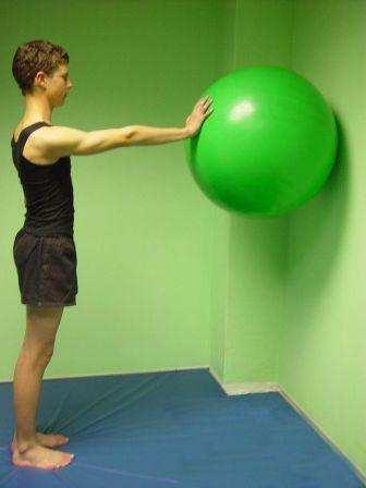Hold ball firmly with one hand against wall at chest level.
