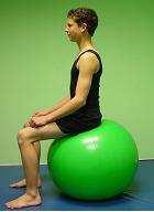 Rest your neck comfortably on the ball with the feet underneath the knees and arms outstretched for balance if necessary. Lift your hips so that the spine is in the neutral position.