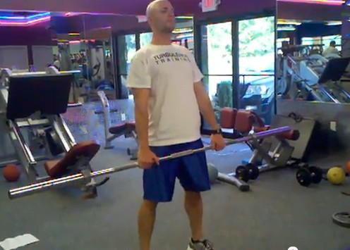 Hold a barbell at arms length. Stand with your feet shoulder-width apart.
