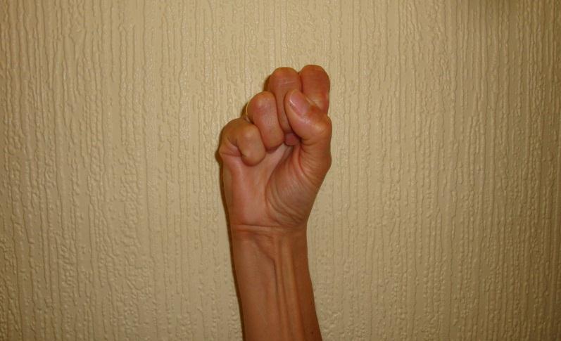 Make a Fist Start with your fingers straight. Spread your fingers apart. Gently try to make a loose, gentle fist and wrap your thumb around the outside of your fingers.