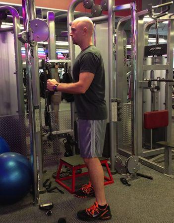 Workout B Tricep Pushdowns Stand in front of a cable machine with a rope or