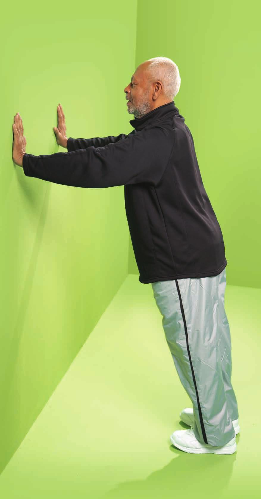 3 Slowly bend your elbows and lower your upper body toward the wall. Keep your feet flat on the floor.