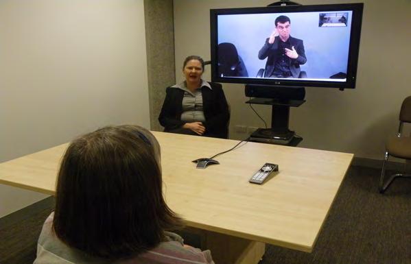 The interpreter works from a VRI suite (at Vicdeaf); the Deaf and hearing people are situated offsite generally in a workplace setting.