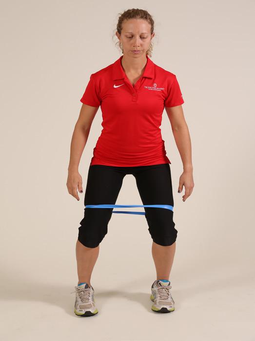 The exercise can be done with the band above the knee, at the ankles or around the middle of the foot.