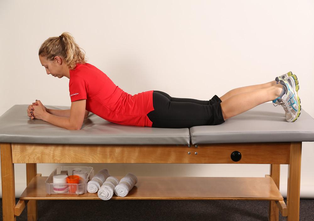 Lie on your stomach. Place your elbows under your shoulders for support and rest your weight on your forearms. Place the tips of your toes on the table for support.