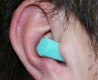 roll and compress the earplug tightly along its entire length into a crease free cylinder