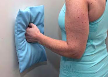 While standing Stand with your injured arm touching the wall and elbow bent with a small pillow or towel between your elbow and the wall. Push your elbow sideways against the wall.