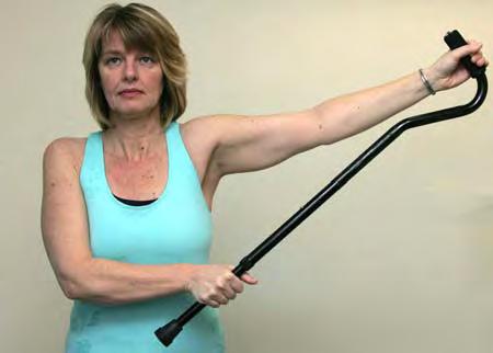 Hold the stick or cane in front of you with both hands. Cup your hand of the injured arm over one end.