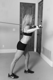 ) Stand 3-4 feet away from the door, facing the door with the knees bent and the body bent over at about a 45 degree angle. 3.) Reach forward and grab a hold of the resistance band keeping the elbows relatively straight.