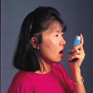 STEP 2: Hold the inhaler like this stand up, take a deep breath, and breathe out as much as you