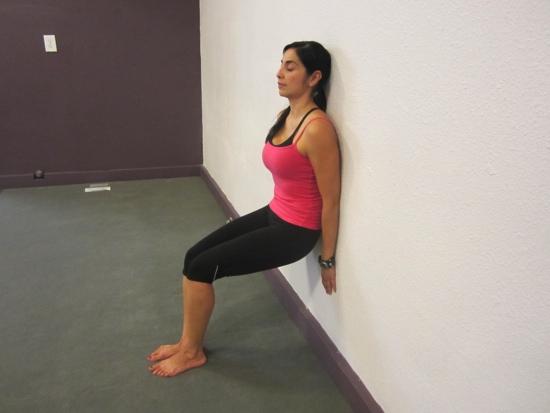 Wall Knee Lift Begin by standing up against a wall. Walk feet forward in front of the body. Head back up against the wall shoulders open as pressed to the wall.