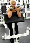 Preacher Hammer Dumbbell Curl Tips: Position yourself on a preacher bench. Hold two dumbbells in your hands with your palms facing each other.