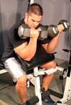 Two Arm Dumbbell Preacher Curl Tips: Sit a preacher bench with two dumbbells. Rest your arms and elbow on the slanted pad.