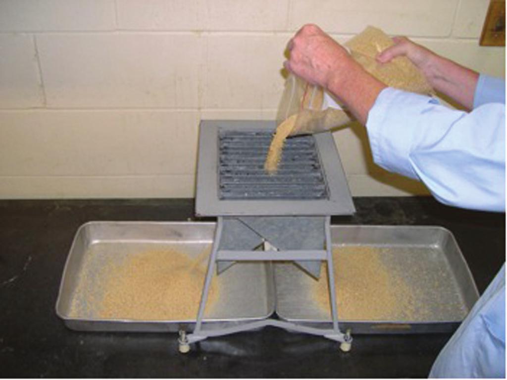 The feed or ingredient sample is poured into the riffler; the sample flows down a series of two chutes that discharge alternately in opposite directions into separate pans.