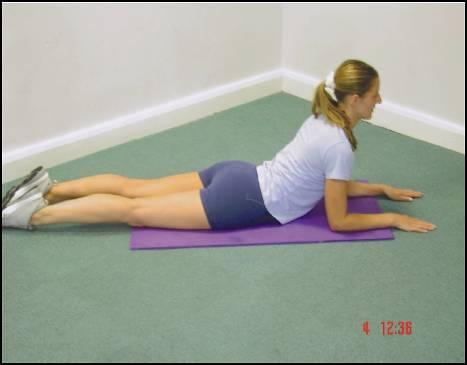 STRETCH: Sphinx Client lies pronated on an exercise mat with elbows under shoulders