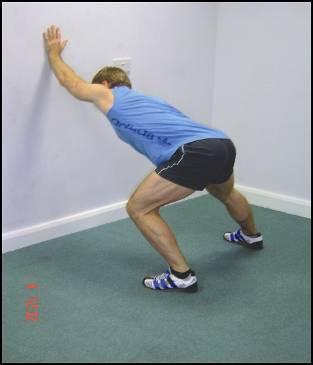 STRETCH: Standing wall assisted latissimus dorsi Stand in front of a wall in a wide stance at arms