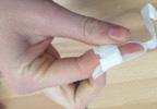 Using one piece of tape, secure the splint onto the finger as shown. 2.