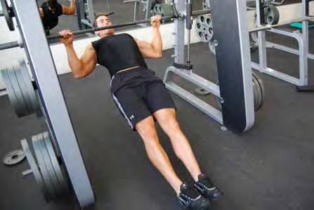 wider than shoulder width with your legs slightly bent Pull yourself up and touch your chest to the bar on each rep (if