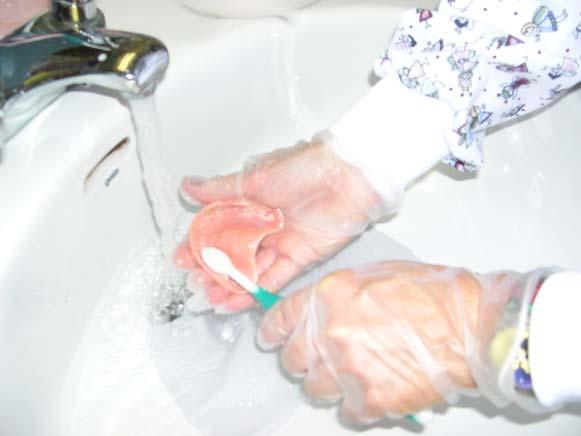 Scrubbing a Denture Place paper towel or wash cloth in sink to prevent breakage if