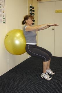 In standing- try squatting at a wall with the ball supporting your back.