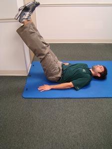 Lying flat on your back in a doorway, place your right leg up against a wall and stabilize your core.