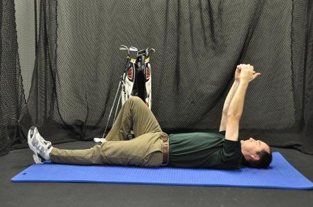 Start by lying flat on your back with your knees bent and arms extended out in front of you.